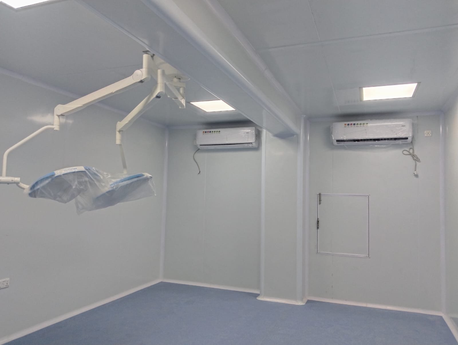 Operating room with ceiling surgical light and two wall-mounted air conditioners